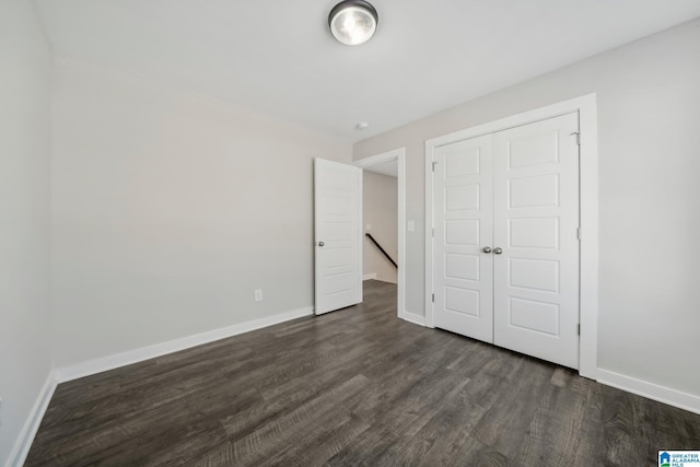 unfurnished bedroom with dark hardwood / wood-style floors and a closet