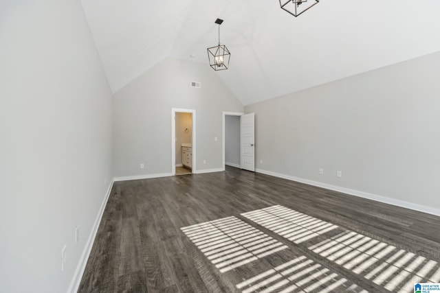 interior space with a chandelier, ensuite bathroom, dark wood-type flooring, and lofted ceiling