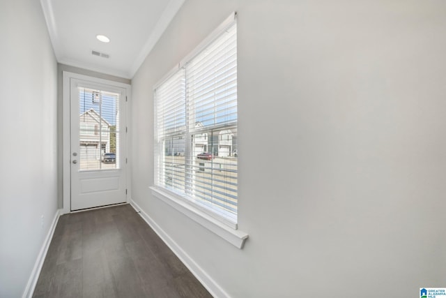 doorway with dark hardwood / wood-style flooring and crown molding