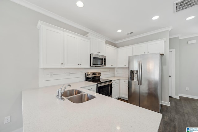 kitchen featuring white cabinets, sink, dark hardwood / wood-style floors, ornamental molding, and stainless steel appliances