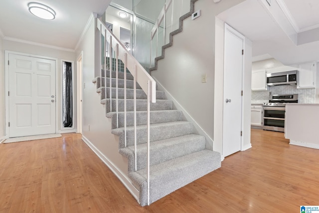 stairway featuring crown molding and wood-type flooring