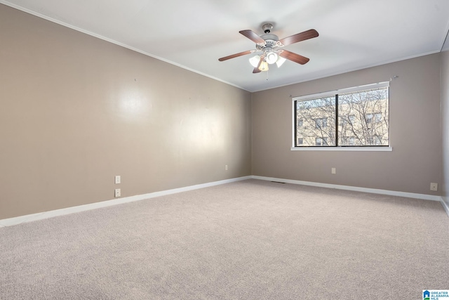 carpeted empty room with ceiling fan and ornamental molding