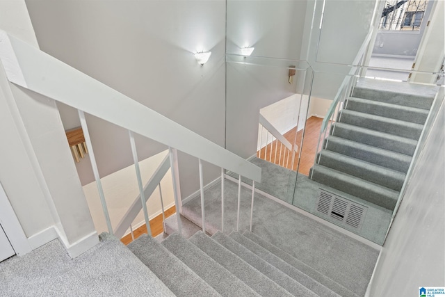 stairway featuring carpet flooring