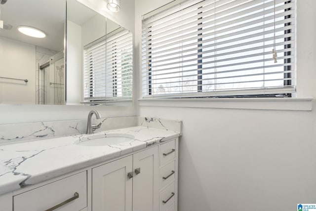 bathroom featuring vanity, an enclosed shower, and a wealth of natural light