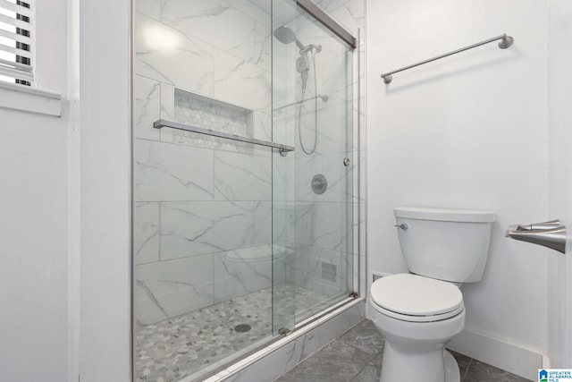 bathroom featuring toilet and a shower with door