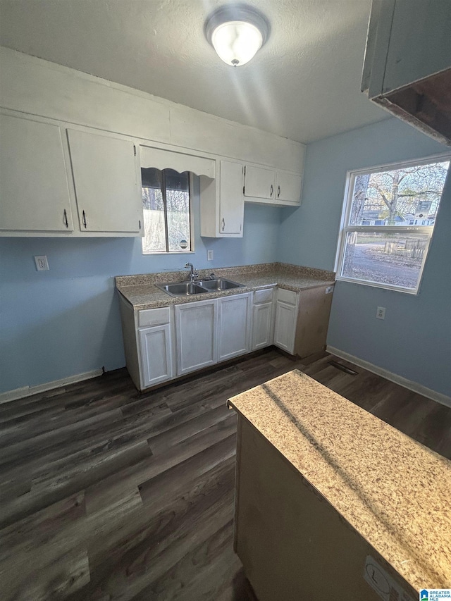 kitchen with dark hardwood / wood-style flooring, white cabinetry, sink, and plenty of natural light