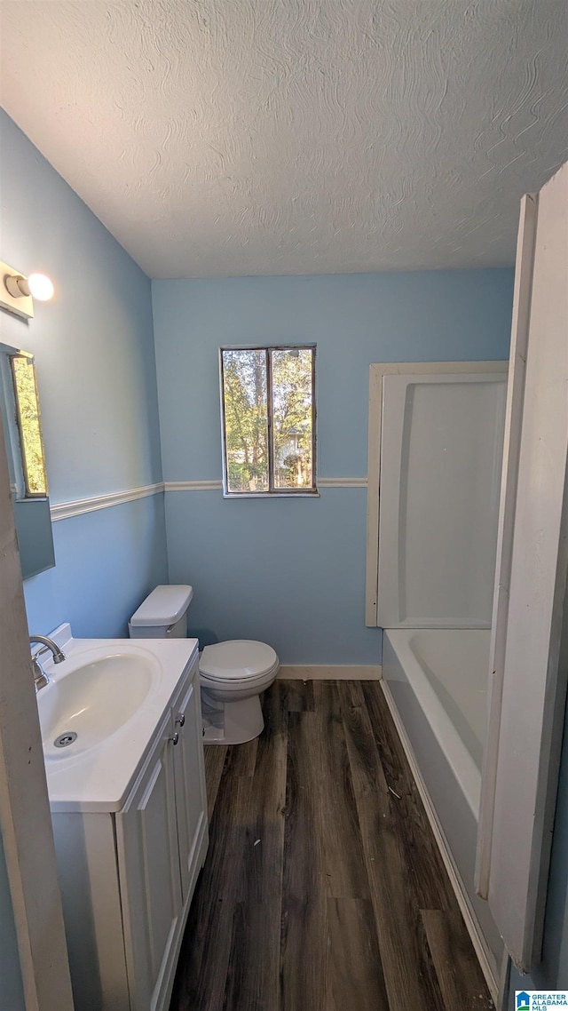 bathroom featuring toilet, vanity, a textured ceiling, and hardwood / wood-style flooring