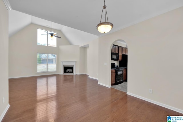 unfurnished living room featuring ceiling fan, wood-type flooring, and vaulted ceiling