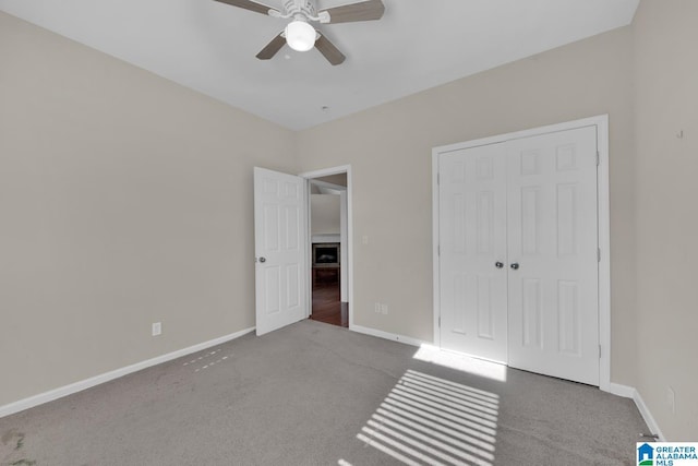 unfurnished bedroom with ceiling fan, light colored carpet, and a closet