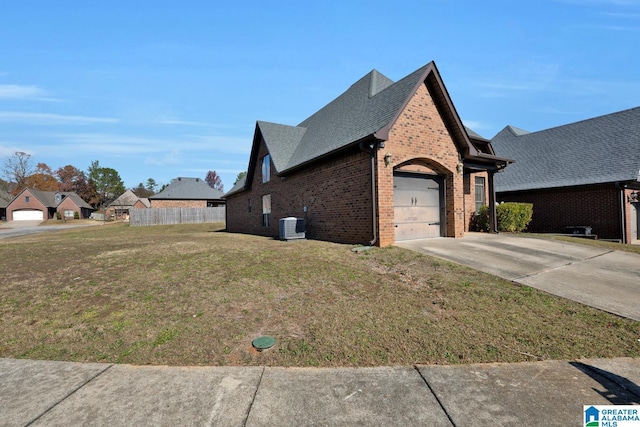 view of home's exterior featuring a lawn, central AC, and a garage