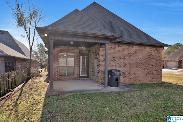 back of property with a lawn and a patio