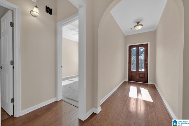 foyer entrance featuring crown molding and wood-type flooring