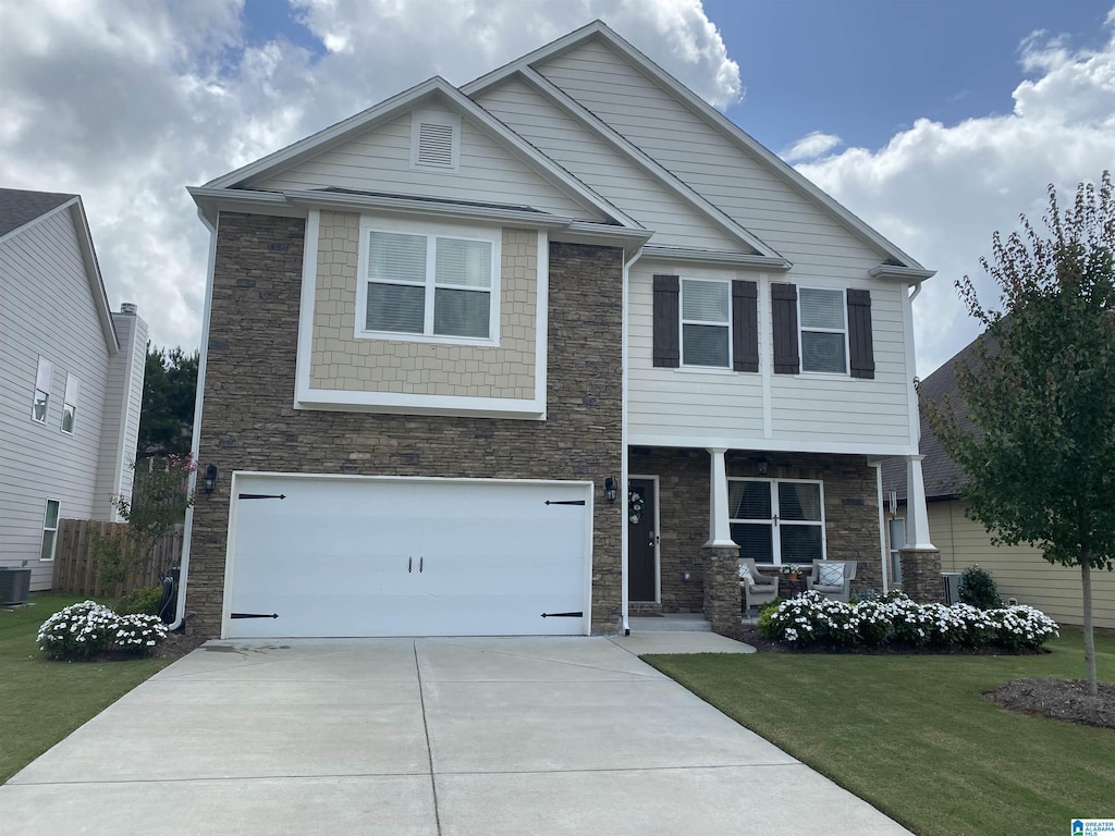 view of front of property with a garage, central air condition unit, and a front yard