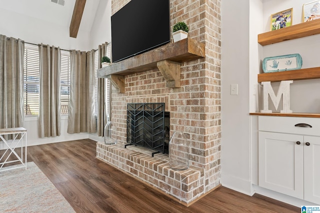 living room with hardwood / wood-style flooring, lofted ceiling with beams, and a brick fireplace