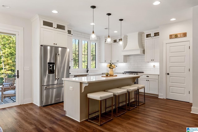 kitchen featuring white cabinets, a kitchen island, custom range hood, and stainless steel appliances