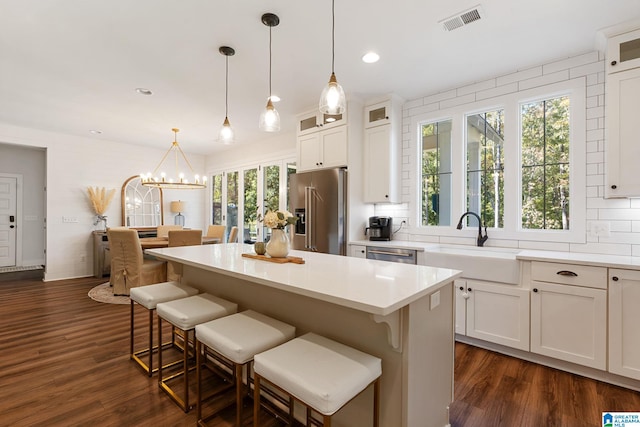 kitchen with white cabinets, pendant lighting, and stainless steel appliances