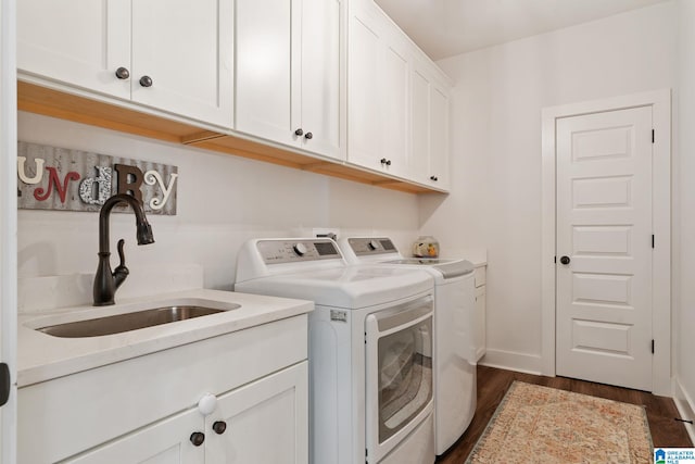 laundry room featuring cabinets, washing machine and dryer, sink, and dark wood-type flooring