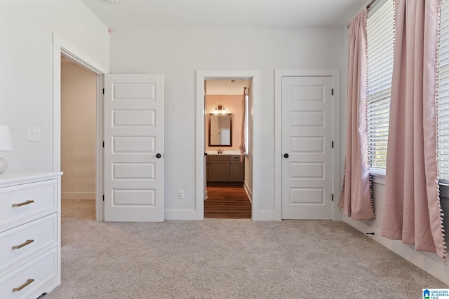 unfurnished bedroom with light carpet and connected bathroom