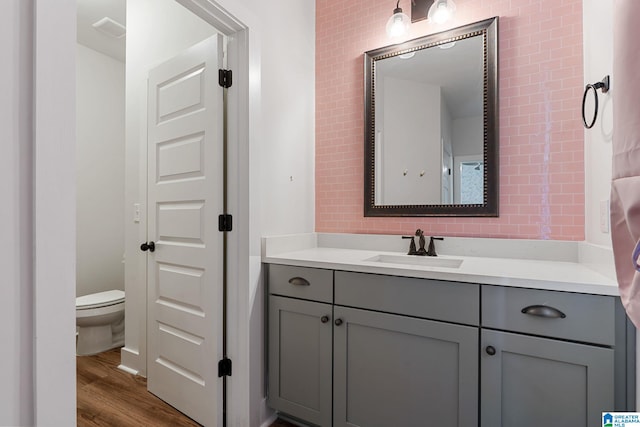 bathroom featuring vanity, wood-type flooring, and toilet