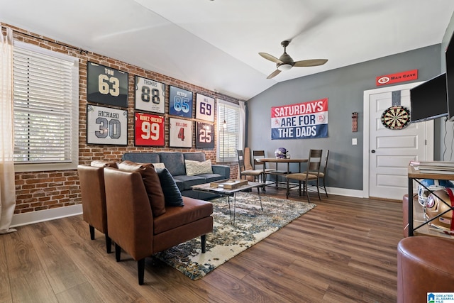 living room with wood-type flooring, vaulted ceiling, ceiling fan, and brick wall