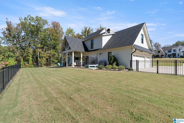 back of house featuring a lawn and a garage