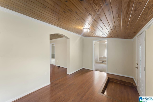 empty room featuring wood-type flooring, ornamental molding, and wooden ceiling