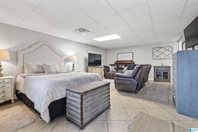 bedroom with a drop ceiling and light tile patterned flooring