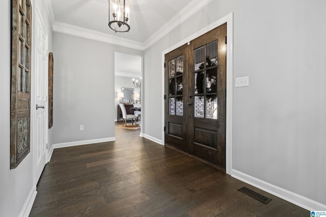 entryway featuring dark hardwood / wood-style flooring, french doors, ornamental molding, and a chandelier