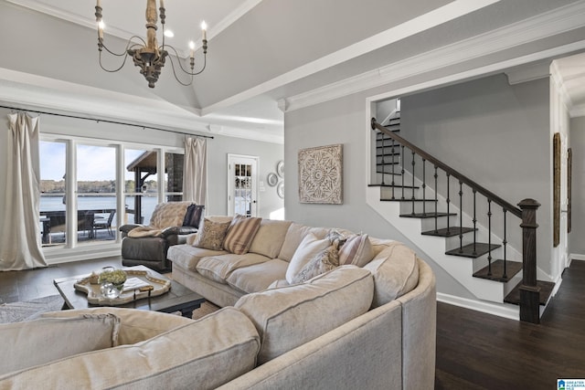 living room featuring a raised ceiling, dark hardwood / wood-style floors, crown molding, a chandelier, and a water view