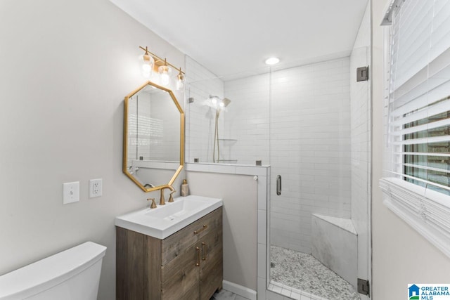 bathroom featuring a shower with door, vanity, and toilet