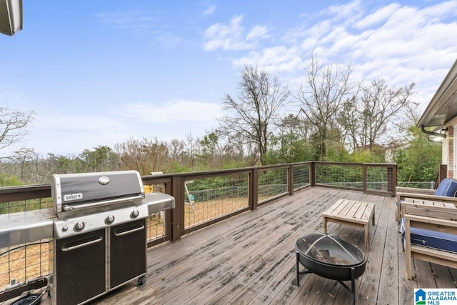 wooden deck featuring grilling area and a fire pit