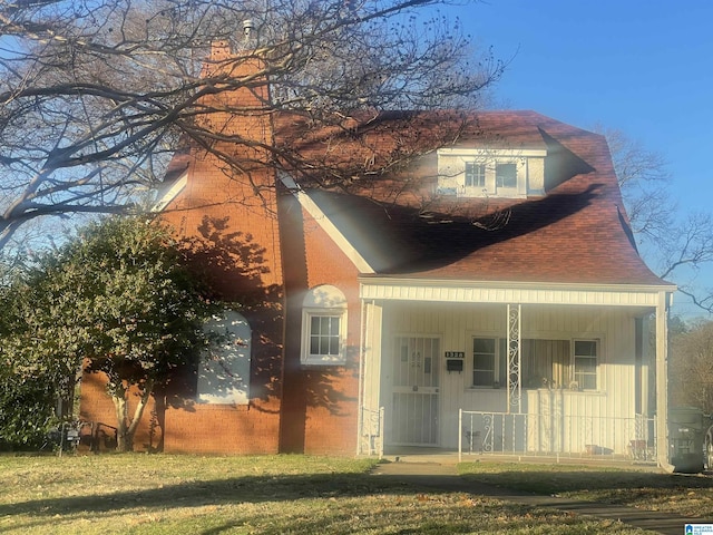 view of front of house with a porch and a front yard