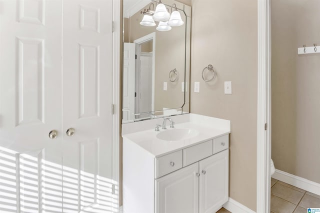 bathroom with tile patterned flooring, vanity, a chandelier, and toilet