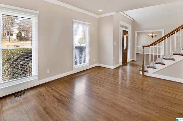 entryway with hardwood / wood-style flooring, an inviting chandelier, and ornamental molding