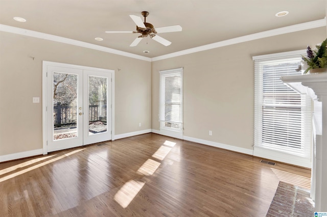 empty room featuring french doors, hardwood / wood-style flooring, ceiling fan, and crown molding