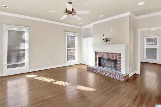 unfurnished living room featuring a brick fireplace, ceiling fan, dark hardwood / wood-style flooring, and ornamental molding