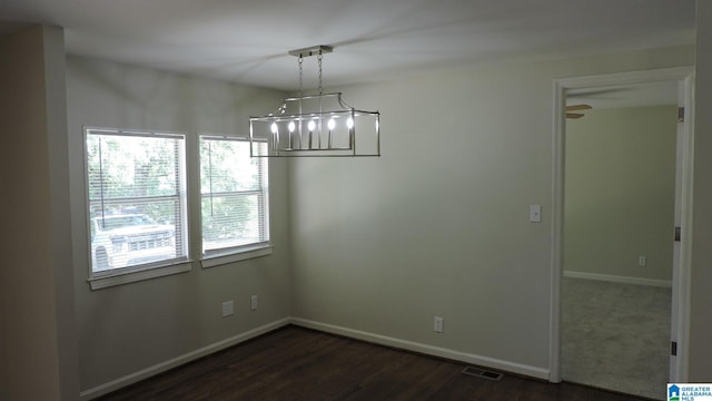 unfurnished dining area with dark wood-type flooring