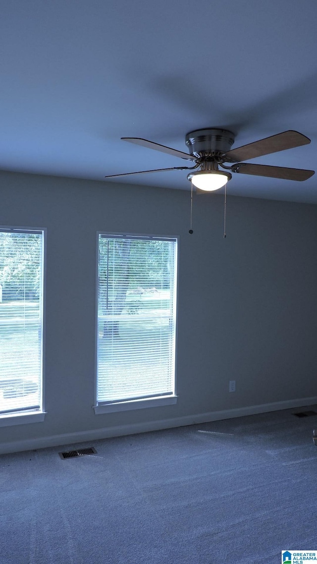 carpeted empty room featuring a wealth of natural light and ceiling fan