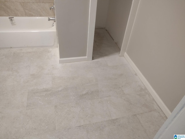 bathroom featuring tile patterned floors and a bath