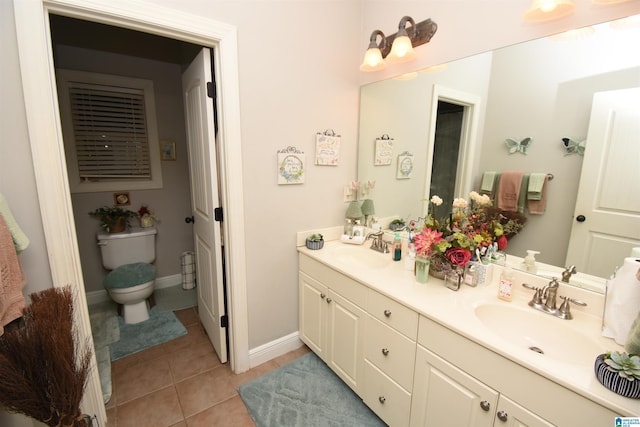 bathroom with tile patterned flooring, vanity, and toilet