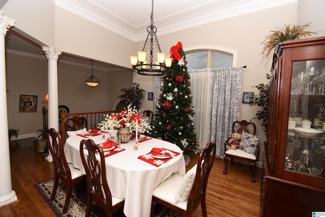 dining space featuring decorative columns, crown molding, dark hardwood / wood-style flooring, and an inviting chandelier