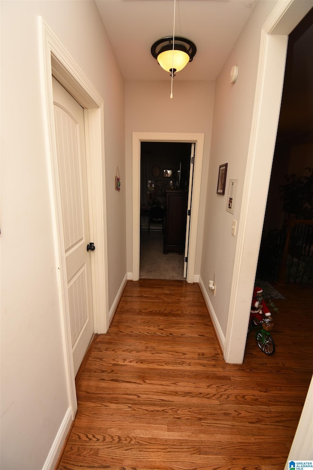 corridor with hardwood / wood-style flooring