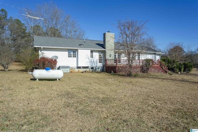 back of property featuring a yard, a wooden deck, and central AC