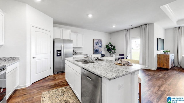 kitchen featuring appliances with stainless steel finishes, a kitchen island with sink, dark wood-type flooring, sink, and white cabinetry