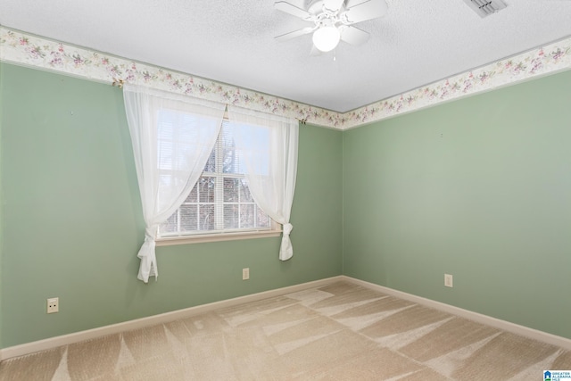 carpeted spare room featuring ceiling fan and a textured ceiling