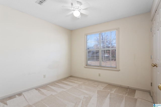 empty room with ceiling fan and light carpet