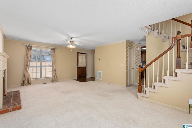 unfurnished living room with a brick fireplace, ceiling fan, carpet floors, and ornamental molding