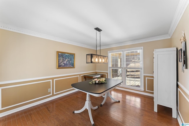 dining space with hardwood / wood-style flooring and ornamental molding