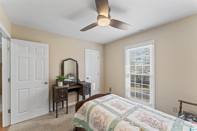 carpeted bedroom with ceiling fan and a textured ceiling