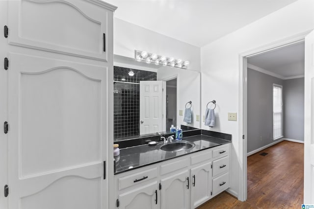 bathroom featuring a shower, vanity, ornamental molding, and hardwood / wood-style flooring